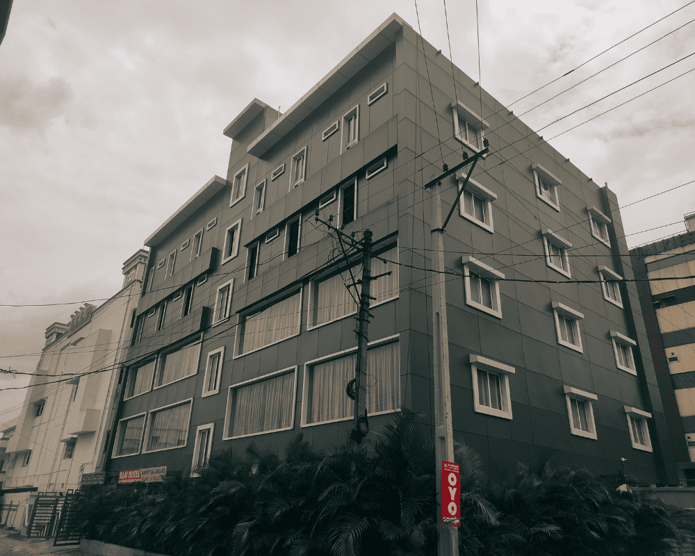 The modern facade of the Nice Roy Nest Raaj Hotel in Mallapur, a commercial project featuring large banquet halls and hotel rooms.